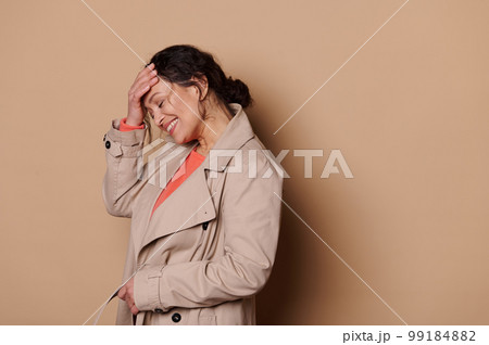 Middle-aged pretty woman in casual coat, laughing and smiling over a beige color background. Successful people concept Middle-aged pretty woman in casual coat, laughing and smiling over a beige color background. Successful people concept 99184882