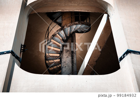 View of old metal spiral staircase inside columnar structures old water tower made of cement. Selective focus. Selective focus. View of old metal spiral staircase inside columnar structures old water tower made of cement. Selective focus. Selective focus. 99184932