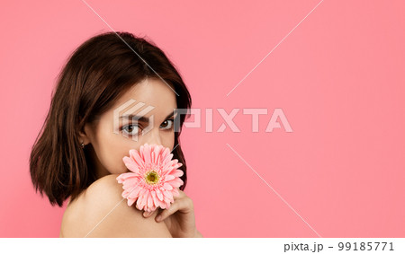 Smiling pretty young european female covering her face with flower, enjoy tenderness, fresh and lifestyle Smiling pretty young european female covering her face with flower, enjoy tenderness, fresh and lifestyle 99185771
