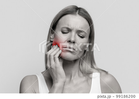 Middle aged woman suffering from strong tooth pain, closeup Middle aged woman suffering from strong tooth pain, closeup 99186200