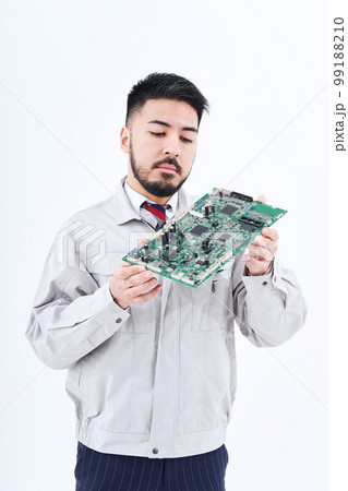 基盤を持つ作業服姿の男性 基盤を持つ作業服姿の男性 99188210