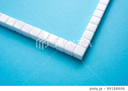 Frame made of white blocks on a blue background. Abstraction, object structure. Place for text, copy space. Turn 90 degrees Frame made of white blocks on a blue background. Abstraction, object structure. Place for text, copy space. Turn 90 degrees 99188606