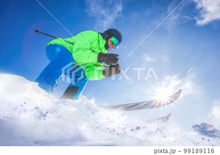 Skier skiing downhill in high mountains against against the fairytale winter forest. 99189116