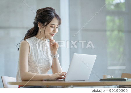 ノートパソコンで作業をする30代のビジネスウーマン カジュアルビジネスイメージ ノートパソコンで作業をする30代のビジネスウーマン カジュアルビジネスイメージ 99190306