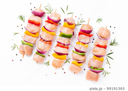 Chicken Skewers breast fillet meat.Uncooked mixed meat skewer.Skewers with pieces of raw meat,red,yellow,green pepper.Top view.Raw chicken skewers with vegetables,peppers,onions,on a white background. 99191363