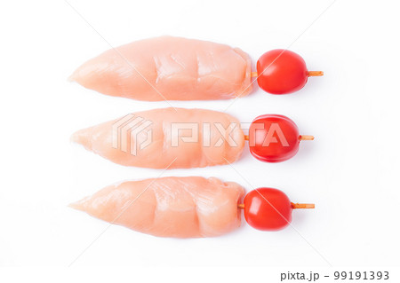 Raw chicken inner on skewers with tomatoes on a white background.Raw uncooked Chicken meat, kebab on skewers on a white background .skewers of raw meat and vegetables.Close-up.Top view. 99191393