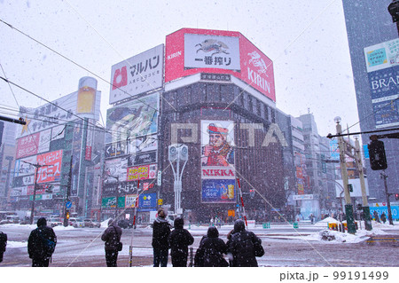 北海道札幌市のすすきの交差点、雪が降り続く南東方向の歓楽街の風景と信号待ちをする歩行者達 北海道札幌市のすすきの交差点、雪が降り続く南東方向の歓楽街の風景と信号待ちをする歩行者達 99191499