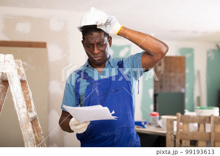 African american foreman examines documents and plans a workflow for repairs 99193613