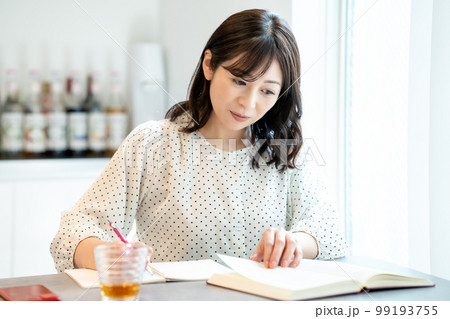 ダイニングテーブルで勉強するミドルの女性 ダイニングテーブルで勉強するミドルの女性 99193755