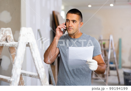 Man having telephone convesrtion in construction site 99194199