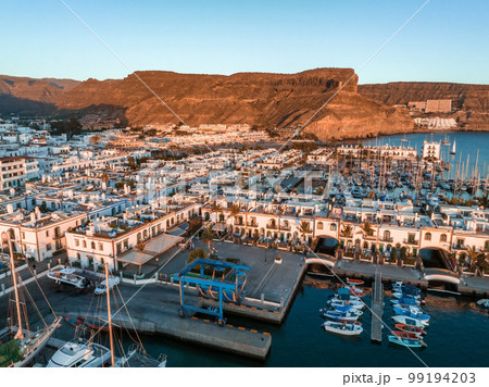 Puerto de Mogan fishing town aerial view at sunset. Traditional colorful buildings with many fishing boats at Gran Canaria, Canary Islands, Spain 99194203