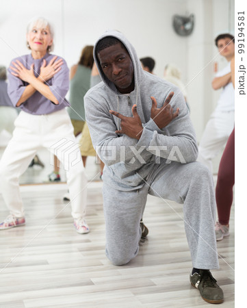 African-american man rehearsing modern hip-hop with group in dance school 99194581