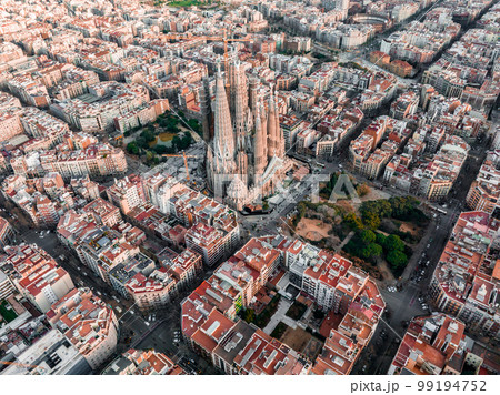 Aerial view of Barcelona City Skyline and Sagrada Familia Cathedral at sunset. Eixample residential famous urban grid. Cityscape with typical urban octagon blocks Aerial view of Barcelona City Skyline and Sagrada Familia Cathedral at sunset. Eixample residential famous urban grid. Cityscape with typical urban octagon blocks 99194752