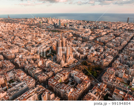 Aerial view of Barcelona City Skyline and Sagrada Familia Cathedral at sunset. Eixample residential famous urban grid. Cityscape with typical urban octagon blocks 99194804