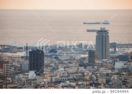Drone shot of ships sailing on beautiful seascape and buildings at the Moll de Gregal del Port Olympic in Barcelona, Catalunya, Spain during sunset 99194944