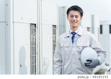 室外機の前に立つ男性作業員 99195145