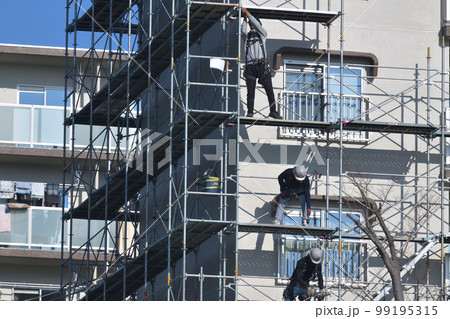 集合住宅のリフォーム　外壁塗装の仮設足場解体作業風景 99195315