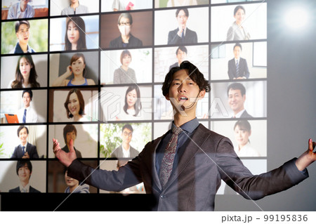 スライドを背景にしてスピーチをする若いビジネスパーソン 99195836