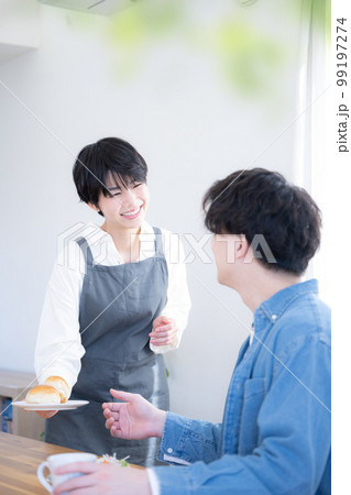 朝食やコーヒーを運んでくる奥さん 見つめ合うカップル	 朝食やコーヒーを運んでくる奥さん 見つめ合うカップル	 99197274