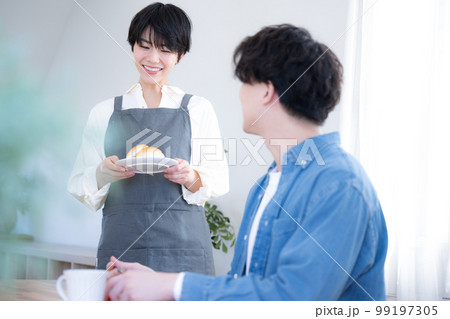 朝食やコーヒーを運んでくる奥さん 見つめ合うカップル	 朝食やコーヒーを運んでくる奥さん 見つめ合うカップル	 99197305