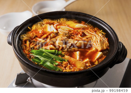 黒い土鍋に入った具沢山なキムチ鍋 99198459