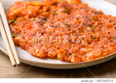 Kimchi pancake (Kimchi jeon or kimchi buchimgae) on plate, Korean food Kimchi pancake (Kimchi jeon or kimchi buchimgae) on plate, Korean food 99198554