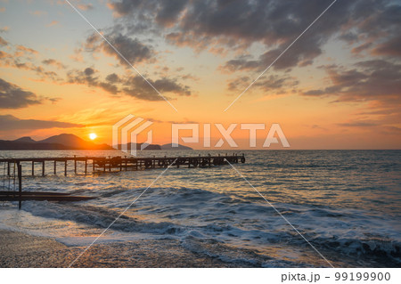 Wooden pier in sea at sunrise. Koktebel. Crimea Wooden pier in sea at sunrise. Koktebel. Crimea 99199900