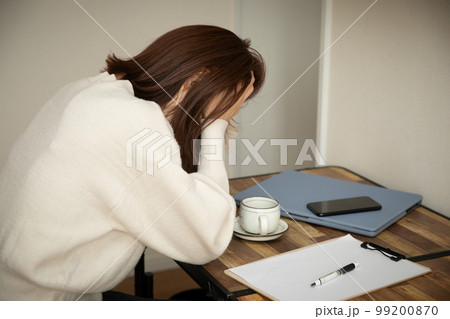 デスクで頭を抱える女性　trouble 99200870