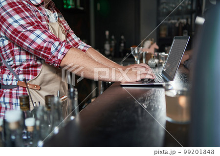 cropped shot of young barista taking notes and using laptop. 99201848