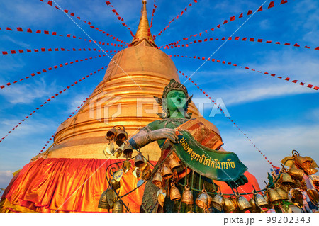 Thai angel by golden stupa in sunlight and blue sky in Buddhist temple. Thai angel by golden stupa in sunlight and blue sky in Buddhist temple. 99202343