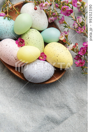 Easter decor. Colored Easter eggs on a wooden plate on the table. Easter decor. Colored Easter eggs on a wooden plate on the table. 99202390