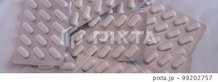 Pile of medical pills in blister pack closeup 99202757