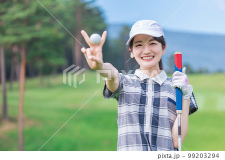 ゴルフ場でゴルフをするゴルフウェアを着たゴルファーの女性（カメラ目線） 99203294