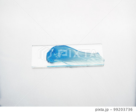 Smear of a blue cosmetic product on a laboratory glass on white background 99203736