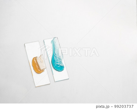 Samples of a multicolored cosmetic product on a laboratory glass on white background Samples of a multicolored cosmetic product on a laboratory glass on white background 99203737