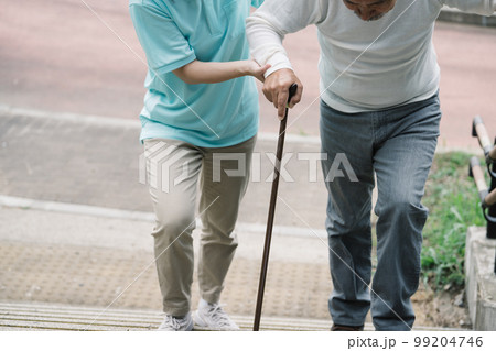 介護士とシニア・リハビリする年配男性とヘルパー 99204746