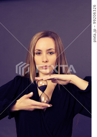 Portrait of satisfied young lady smile hands hold sand clock look camera Portrait of satisfied young lady smile hands hold sand clock look camera 99206326