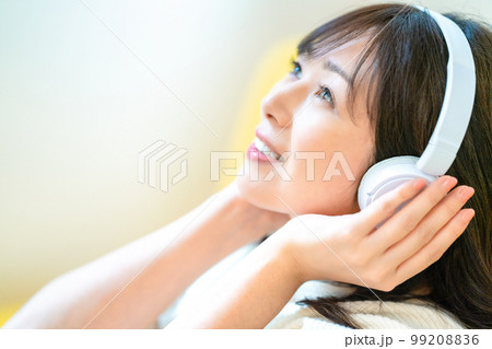 ヘッドホンで音楽を聴くミドルの女性 99208836