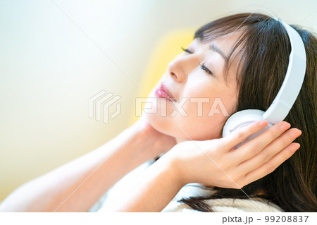 ヘッドホンで音楽を聴くミドルの女性 ヘッドホンで音楽を聴くミドルの女性 99208837