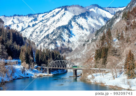 只見線　青空が広がる冬の第四只見川橋梁を渡る列車(福島県金山町、2月) 99209743