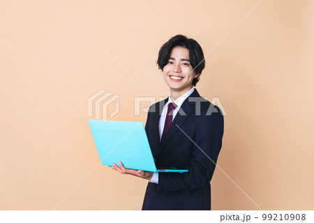 ノートパソコンを持つ若いビジネスマン 99210908