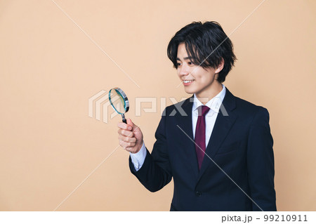 虫メガネで観察する若い男性 99210911