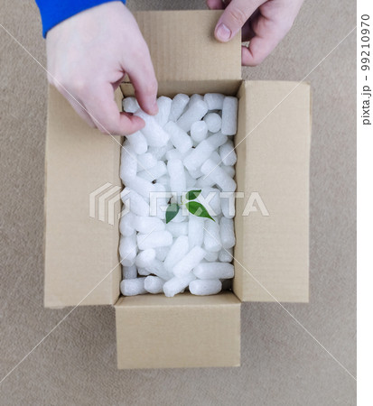 Eco package of parcels and biodegradable filler. Box is filled with a filler that does not harm the environment. Delivery of goods, parcels, delivery service, nature protection. Recycling Eco package of parcels and biodegradable filler. Box is filled with a filler that does not harm the environment. Delivery of goods, parcels, delivery service, nature protection. Recycling 99210970