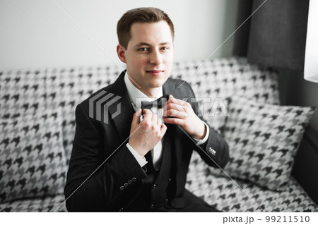 Young handsome man relaxing at his apartment in a hotel after business meeting 99211510