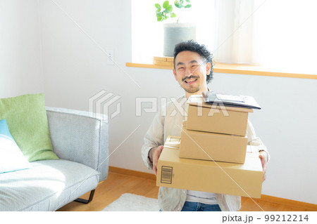 リビングでたくさんの荷物を持つ男性（伝票は撮影のために作成したダミーです） 99212214