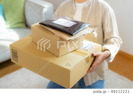 リビングでたくさんの荷物を持つ男性(伝票は撮影のために作成したダミーです) リビングでたくさんの荷物を持つ男性(伝票は撮影のために作成したダミーです) 99212221