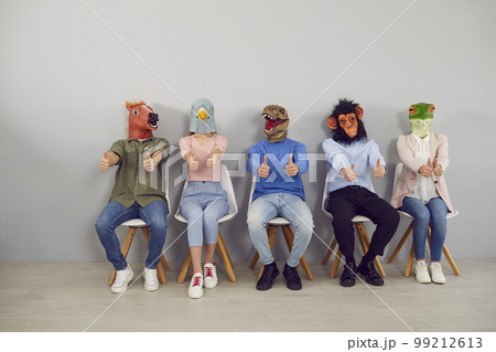 Group of young people in trendy rubber masks of different animals' heads showing thumbs up. Group of young people in trendy rubber masks of different animals' heads showing thumbs up. 99212613