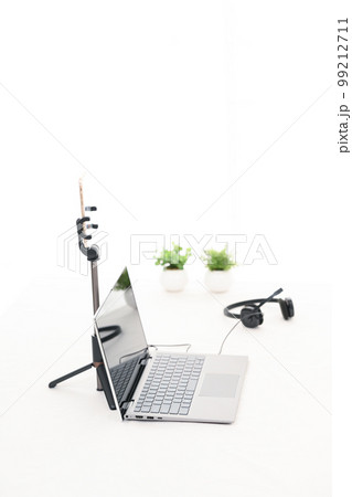白いテーブルにライブ配信用のノートパソコンとスマホとヘッドホンがある様子 白いテーブルにライブ配信用のノートパソコンとスマホとヘッドホンがある様子 99212711