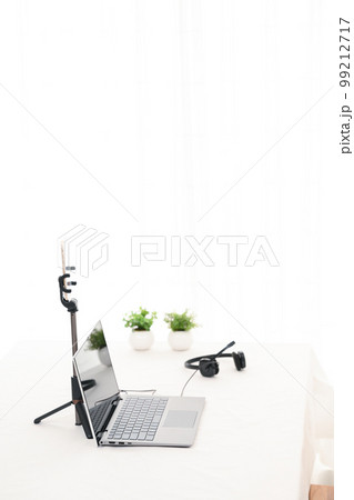 白いテーブルにライブ配信用のノートパソコンとスマホとヘッドホンがある様子 白いテーブルにライブ配信用のノートパソコンとスマホとヘッドホンがある様子 99212717