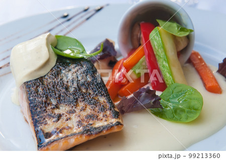 Delicious plate of grilled salmon with pepper garnish Delicious plate of grilled salmon with pepper garnish 99213360